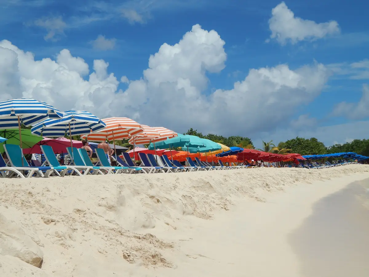 Colorful umbrellas and beach chairs lined up on Governor's Beach, Grand Turk
