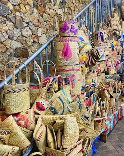 Handmade straw bags and carvings for sale at the Straw Market in Nassau, Bahamas