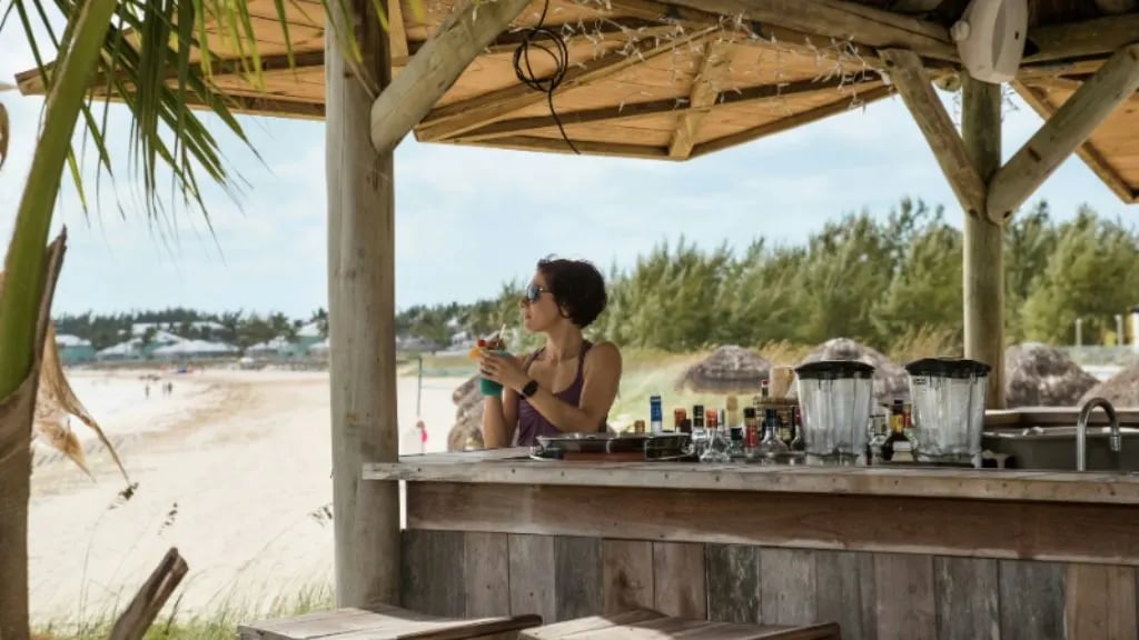 Woman sitting at beach bar in the Bahamas. 